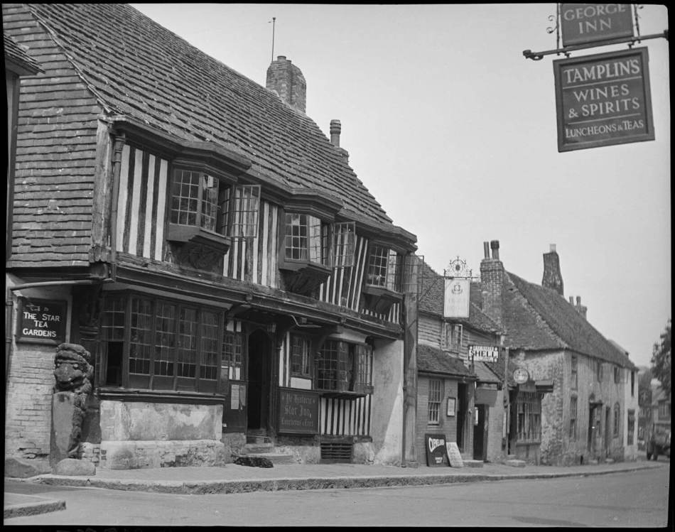 A black and white archive image of the exterior of a timber framed public house.