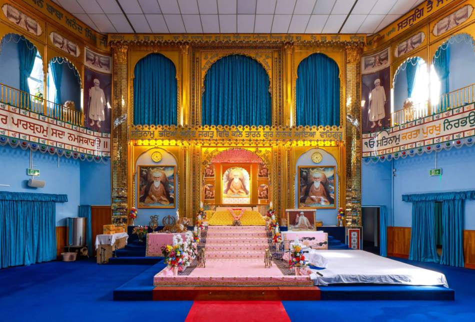 The interior of a cinema converted to a temple, with a shrine on a dias.