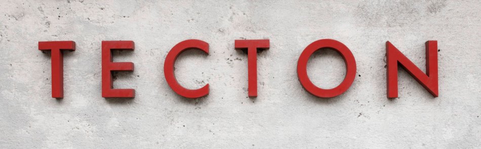 Photograph of a logo spelling out "TECTON" in red relief letters on a wall.