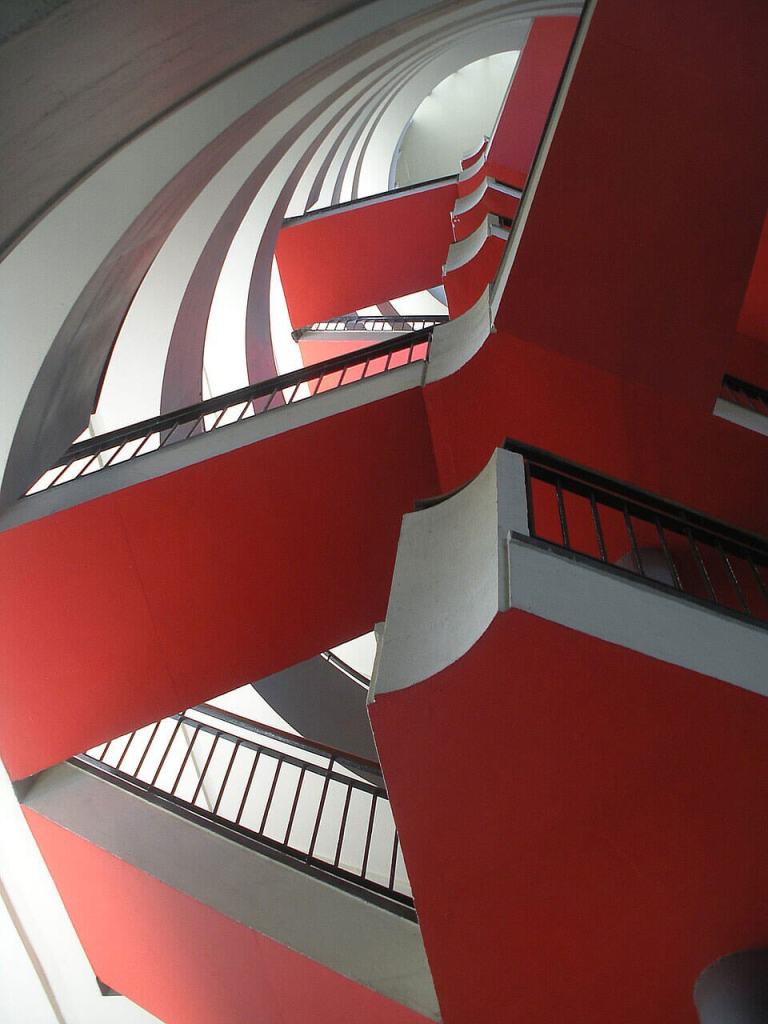 A spiral staircase in a modernist design, painted red and white.