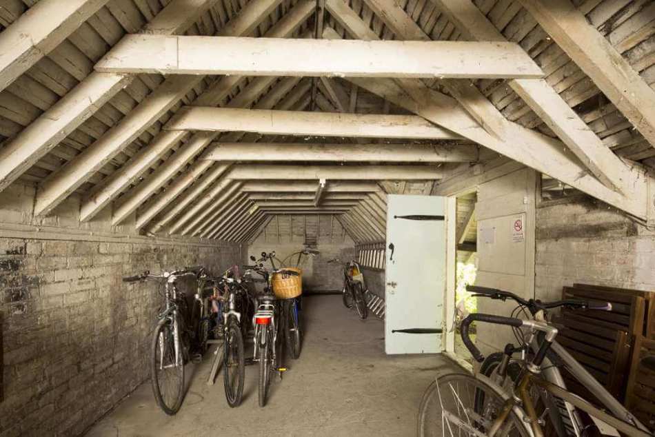 Colour photograph of the interior of bicycle shelter, which is open to the rafters.