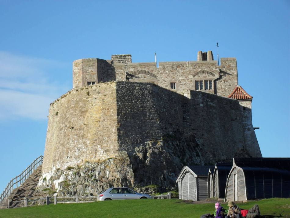 A colour photograph of a stone castle keep built on rock.