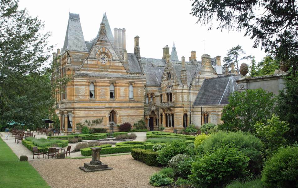 A colour photograph of a gothic-style country house and part of its grounds.