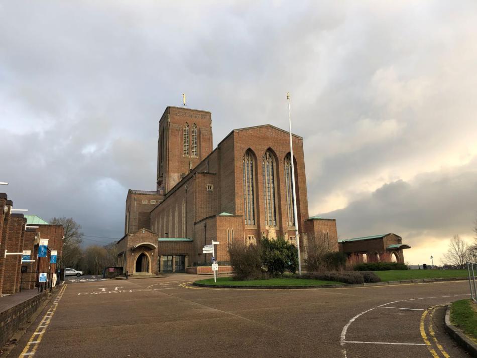 A colour photograph showing a cathedral built of brick against a cloudy sky.