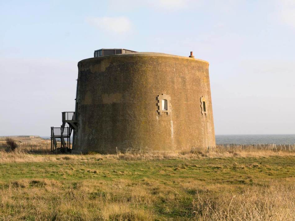 A photograph of a round martello tower with two windows. 
