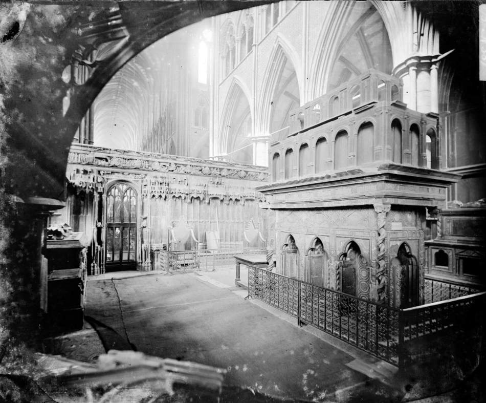 A black and white photograph of a grand tomb inside a large abbey. 