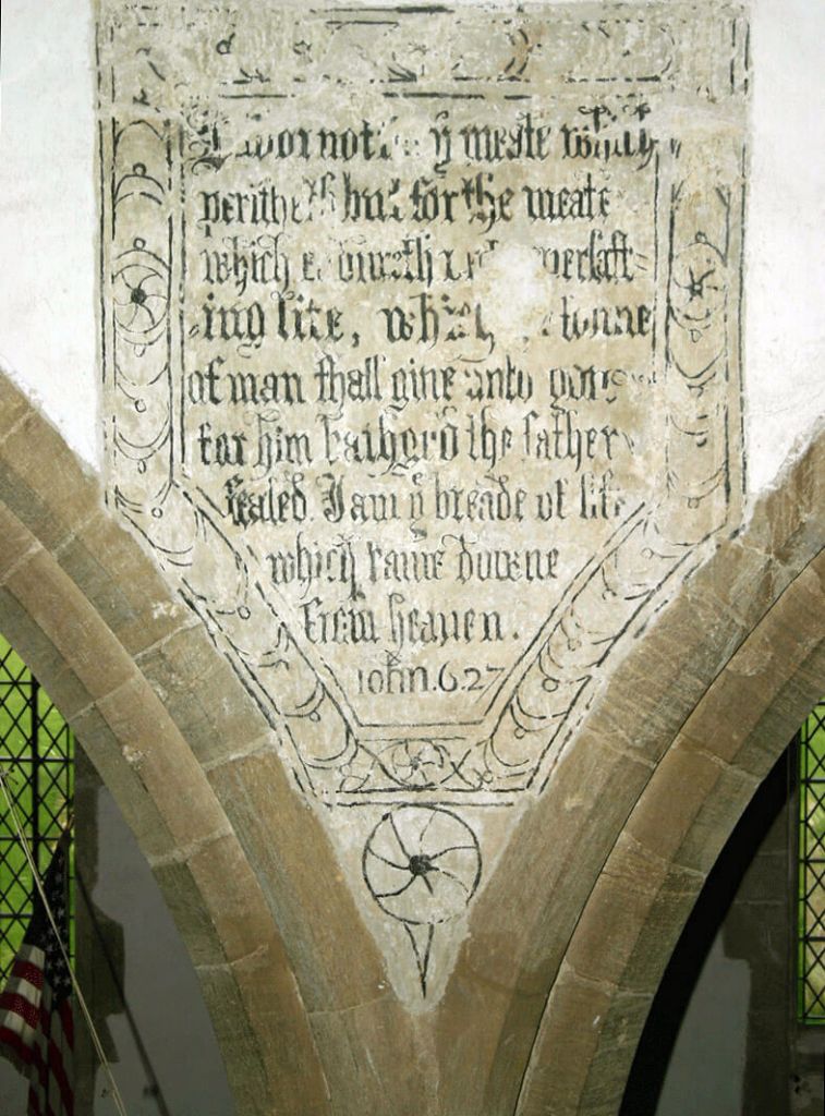 A photograph of a close-up of some Biblical text painted onto the wall of a church.