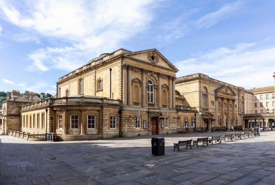 A photograph of a courtyard with a grand Georgian building at its centre. The building includes many elaborate decorative features, including Corinthian columns, Ionic pilasters and pediments.
