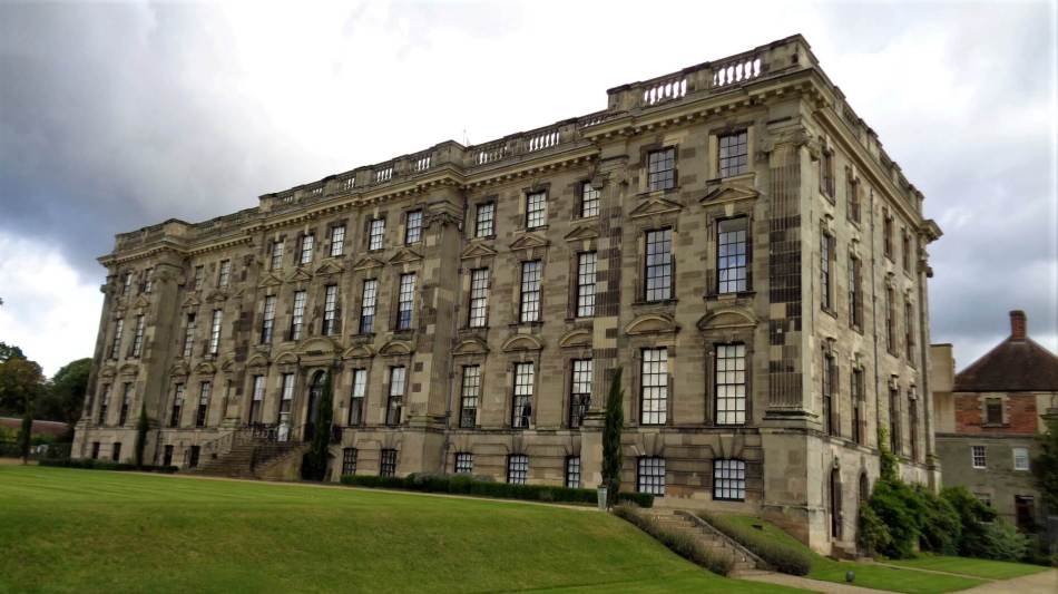 A photograph of the exterior of a grand, 4-storey country house.