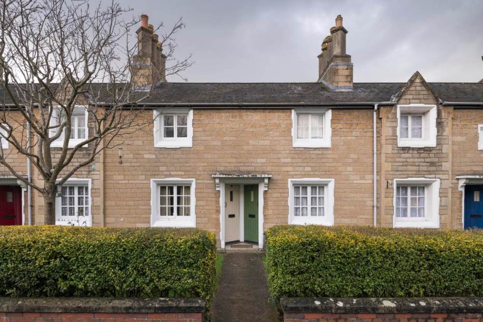 A photograph of a terrace of small, stone cottages.