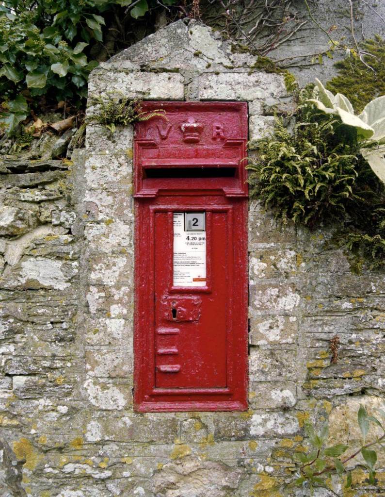A photograph of a post box installed in a wall.