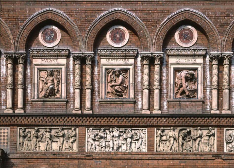 A photograph of stone carvings of various gods and goddesses, as well as scenes of people at work, on the side of a building.