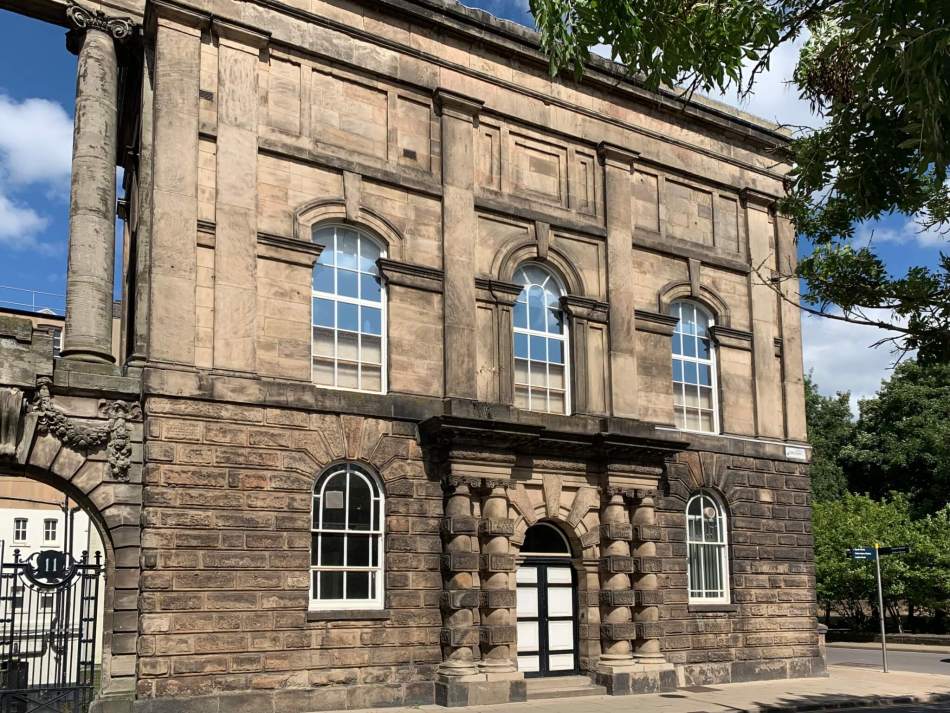A photograph of the exterior of the entrance to a neoclassical style town hall with columns beside the doorway.