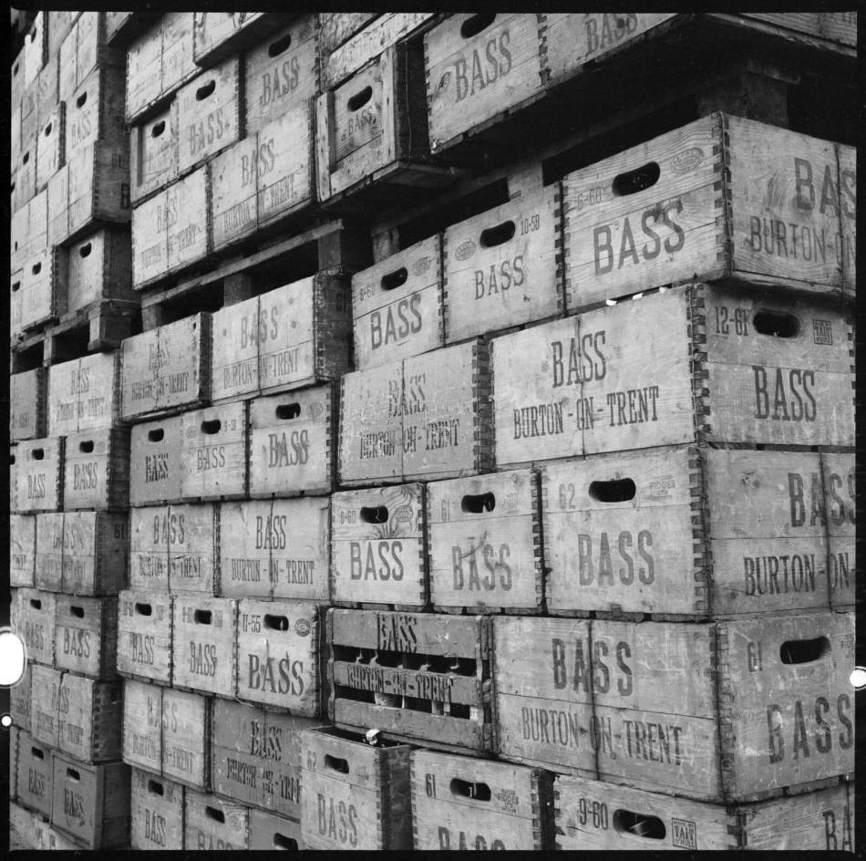 A black and white photograph of crates of Bass beer in storage.