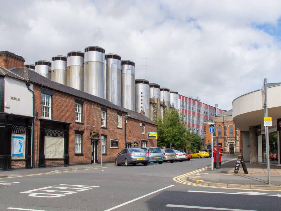 A photograph of a modern brewery, seen from a street junction.