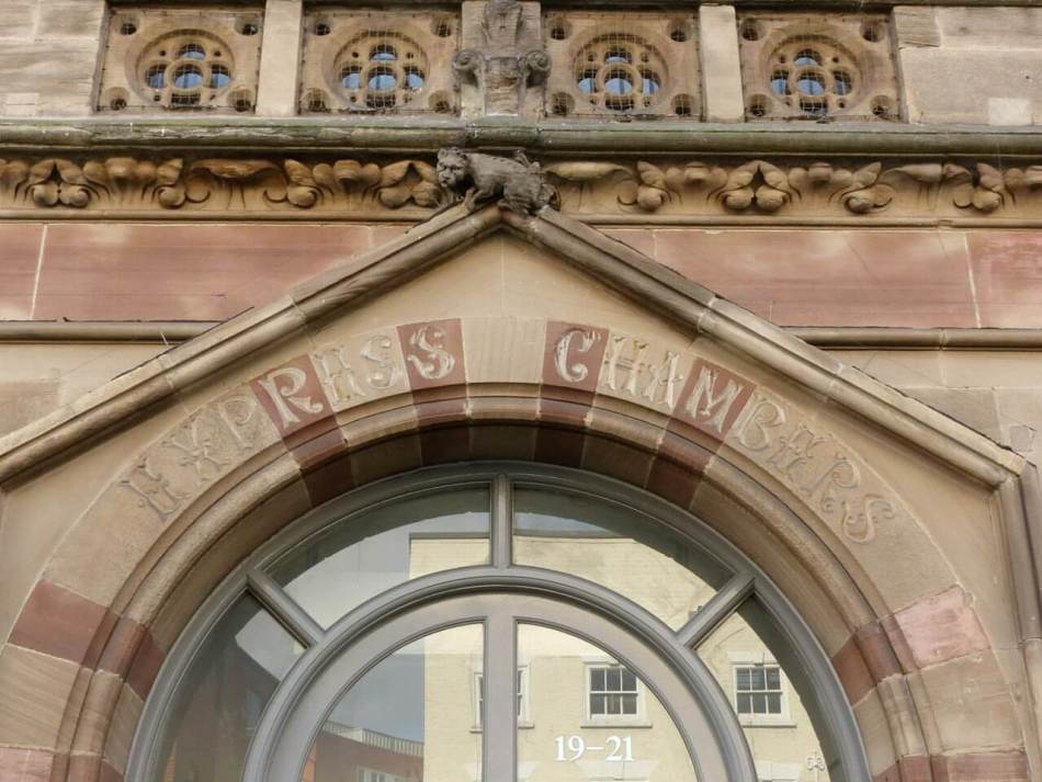 A colour photograph of an ornate doorway with the words "Express Champers" carved in stone. 
