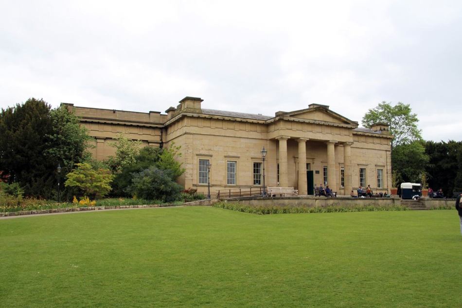 A photograph of the exterior of a museum within a park. 