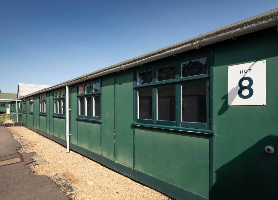 A photograph of a green hut with the number 8 on it. 