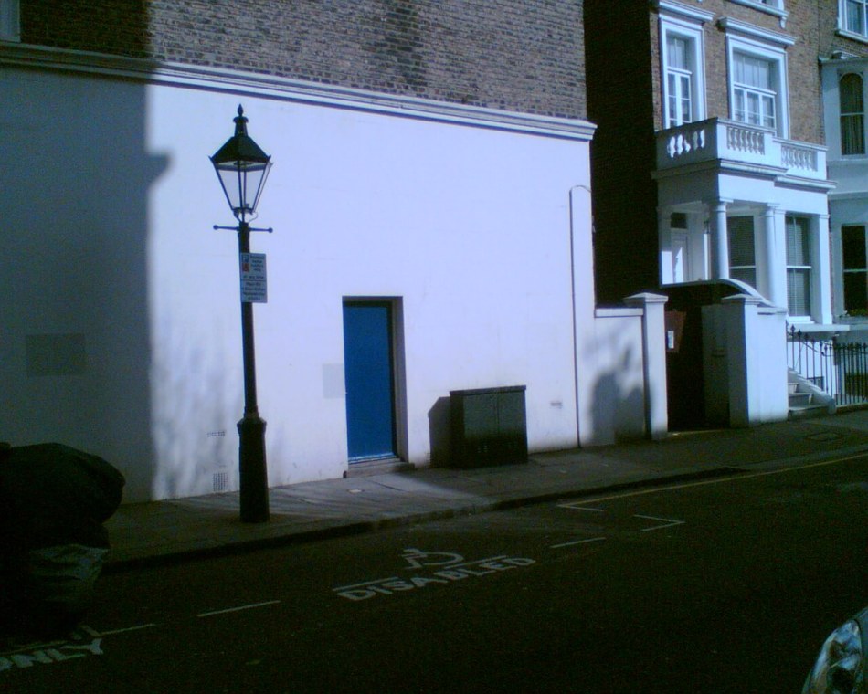 A photograph of a doorway to a club beside a road.