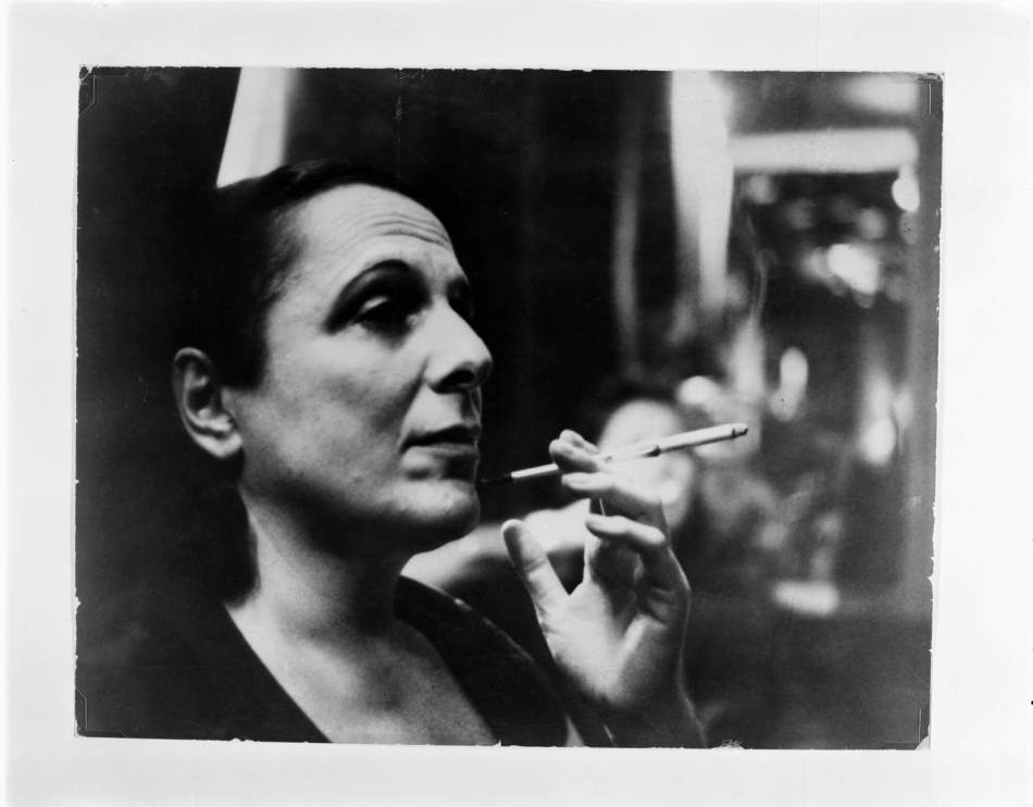 A black and white photograph of a person smoking a cigarette. 