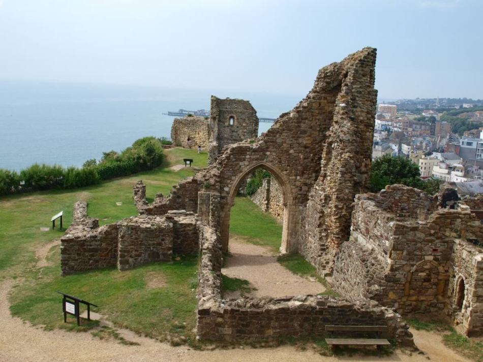 A photograph of a ruined medieval castle overlooking the sea.