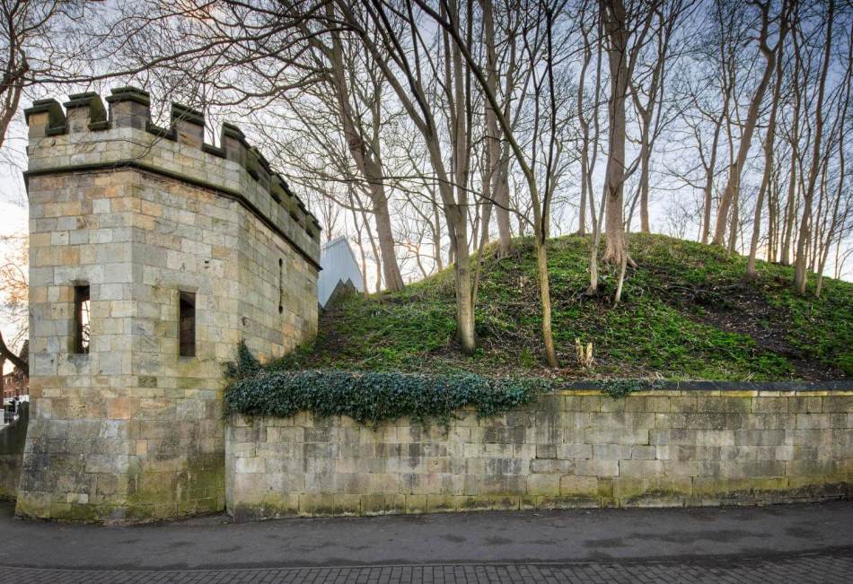 A photograph of a medieval motte and later city walls.