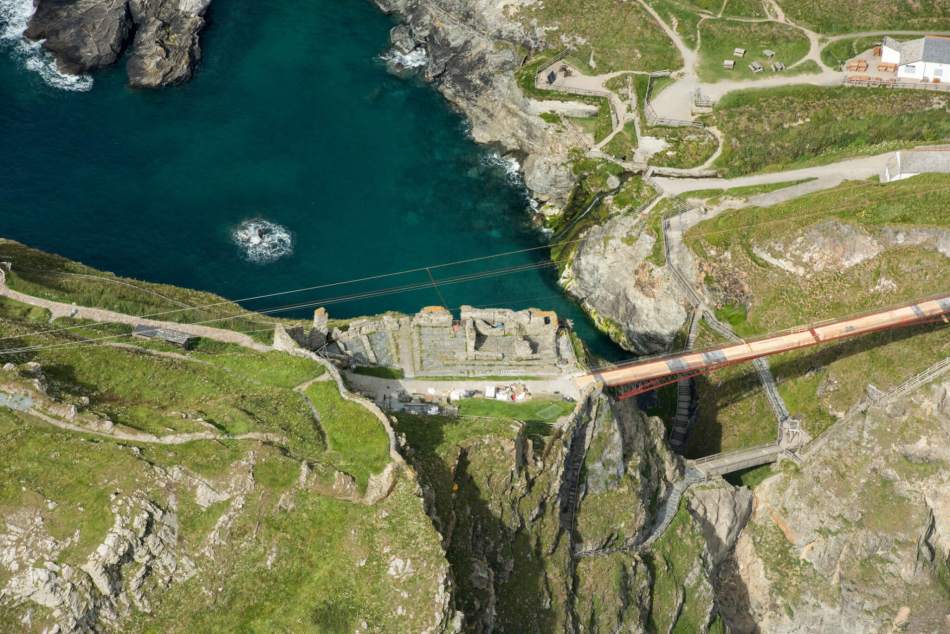 Aerial view of the ruins of a Medieval atop a rocky coastal promontory.