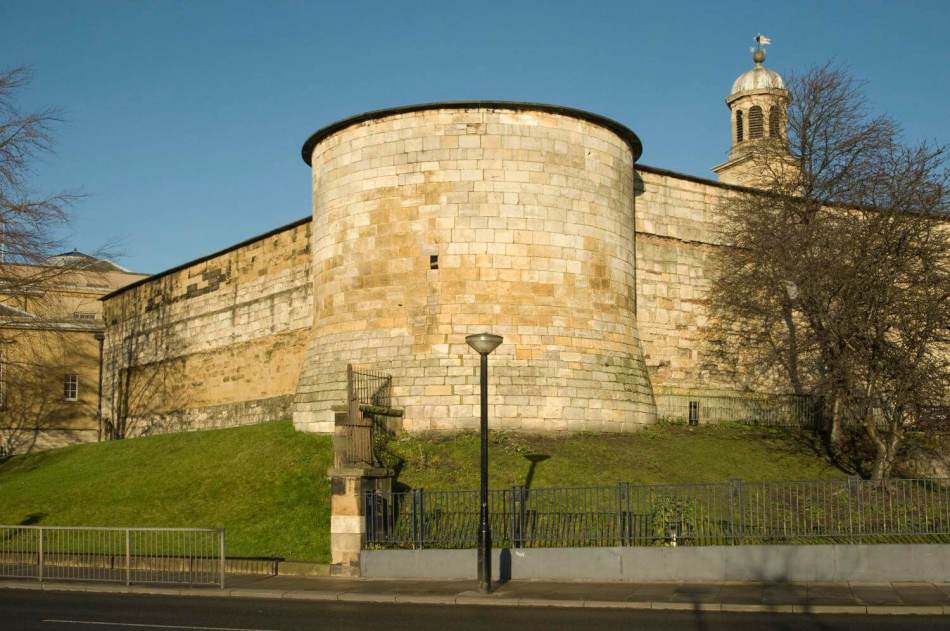 A photograph of the exterior of stone prison walls. 