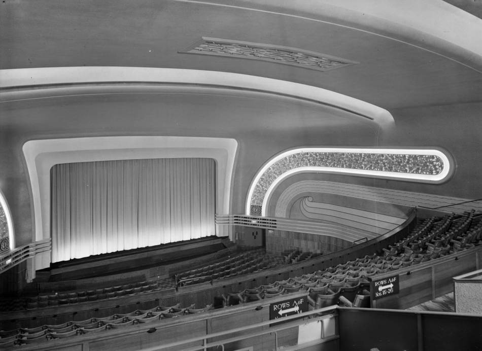 A black and white photograph of an interior of an empty cinema auditorium.