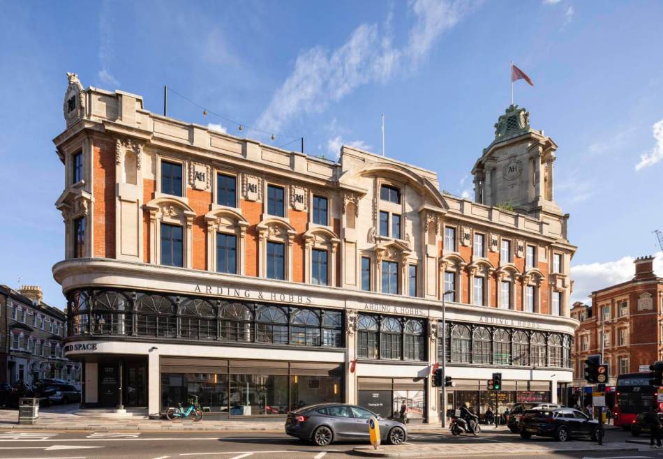 A photograph of a large former Edwardian department store next to a busy road.