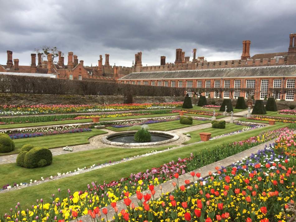 A photograph of the gardens at Hampton Court Palace with colourful flowers.
