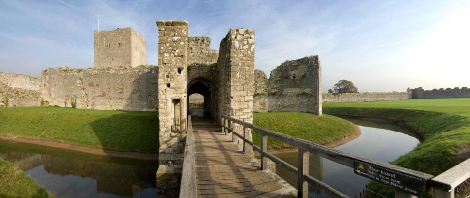 A photograph of the entrance to a castle surrounded by a moat.