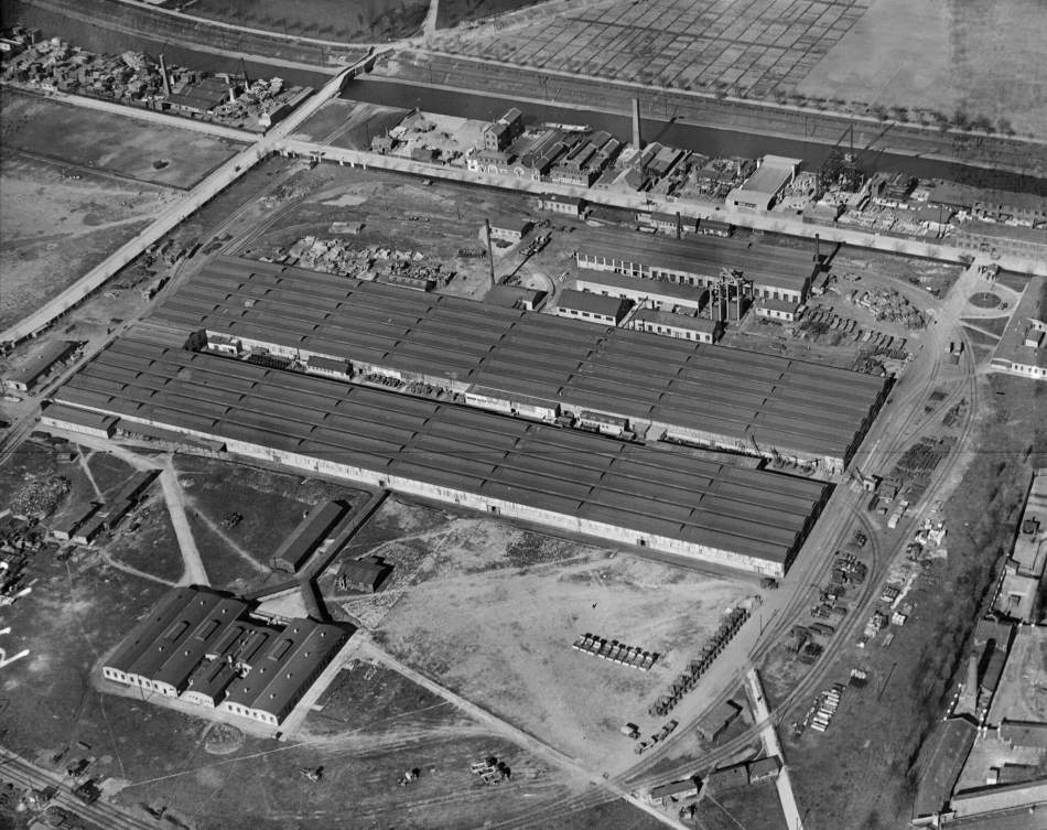 An aerial black and white photograph of a large factory.