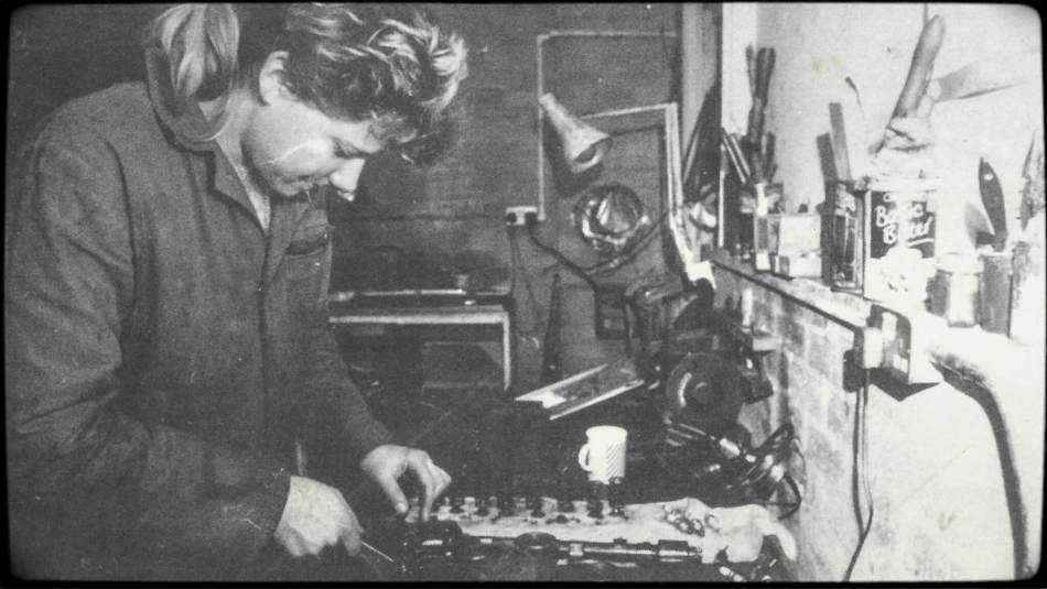 A black and white photograph of a woman in a workshop.