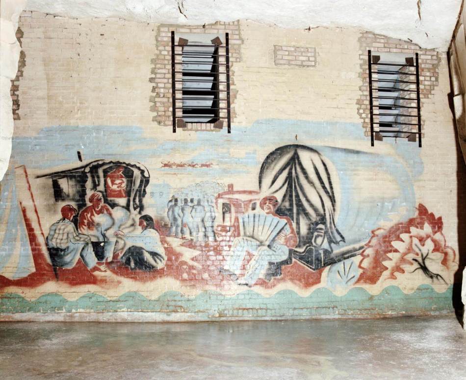 A photograph of a wall mural showing a Gypsy encampment scene. 