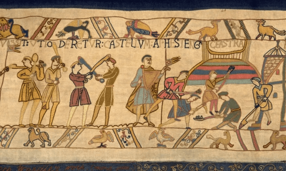 A photograph of an embroidered cloth depicting a motte castle being constructed.