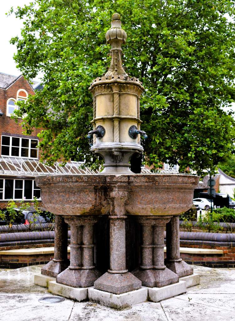 Stone drinking fountain consisting of four semi-circular bowls standing on stone columns, with a central column above bearing taps in the shape of dragon heads.